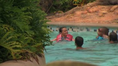 Seaworld Orlando's Aquatica Su Parkı'nda Ön Planda Tropikal Bitkiler ile Hızlı Akan Tembel Nehir Yüzen Can Ceketler Giyen İnsanlar Behind A Close-up.