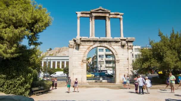 夏の観光シーズン中の晴れた日に古代ギリシャの歴史的建造物を訪れる観光客とハドリアヌスのアテネギリシャアーチ — ストック動画
