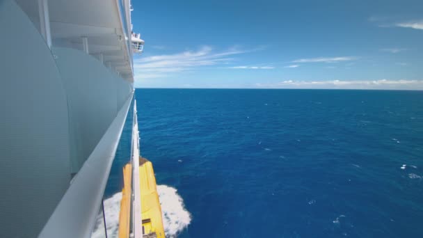 熱帯青海水サイドでの一般的なクルーズ船のセーリングは 牧歌的な天候の間に救命ボートと水しぶき波を見下ろすプライベートバルコニーからの眺め — ストック動画