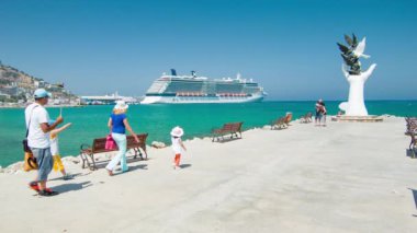 Kuşadası Türkiye Turist Ailesi Manzaralı ve Canlı Güneşli Bir Günde El heykeli Landmark'ı Ziyaret Etti ve Arka Plana Demirledi Cruise Gemisini Ziyaret Etti