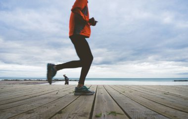 Adam rıhtım boardwalk boyunca jogs