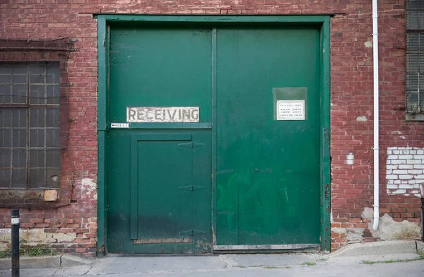 Green doors of a warehouse receiving entrance
