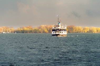Gün batımında Toronto limanıboyunca bir yolcu feribotu yelken açtı