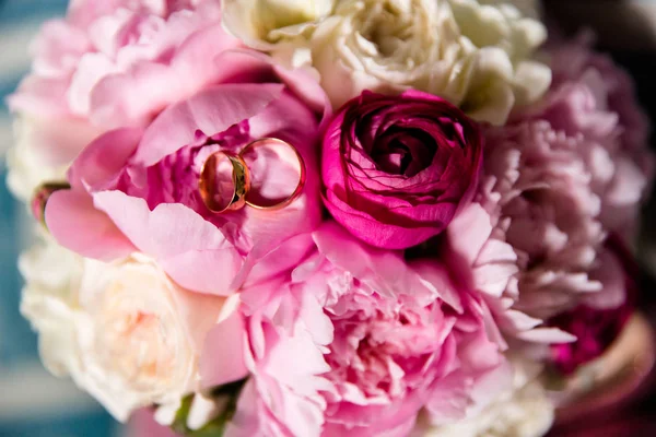 Anéis de ouro de casamento em um buquê de flores — Fotografia de Stock