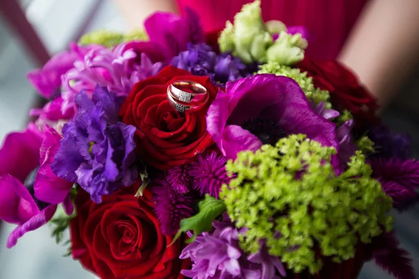 Свадебные золотые кольца на букете цветов — стоковое фото