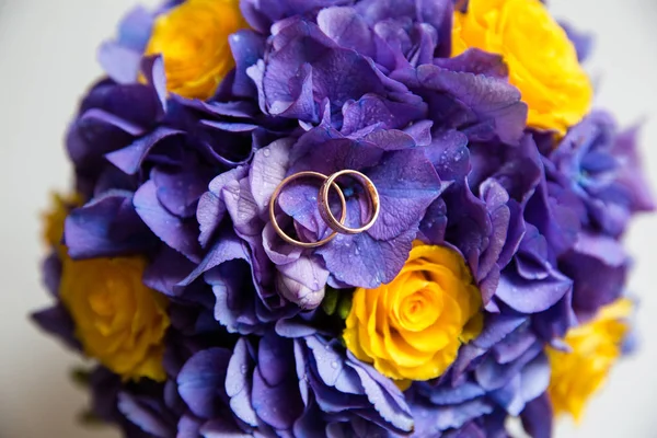 Anillos de oro de boda en un ramo de flores — Foto de Stock