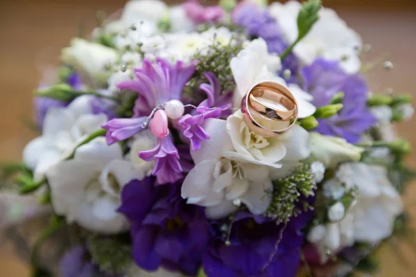 Anillos de oro de boda en un ramo de flores — Foto de Stock