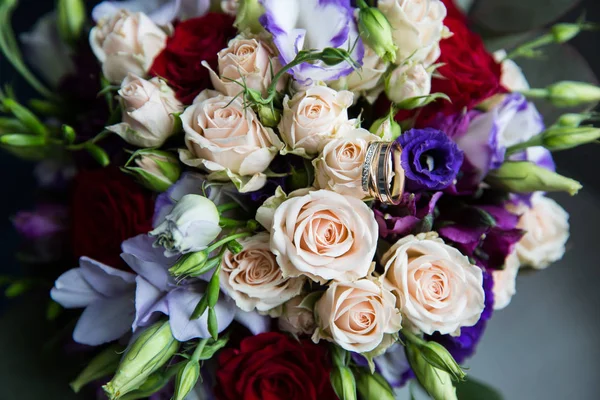 Bagues en or de mariage sur un bouquet de fleurs — Photo