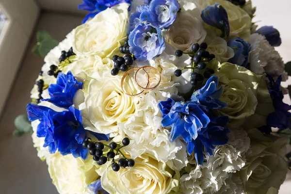 Anillos de oro de boda en un ramo de flores — Foto de Stock