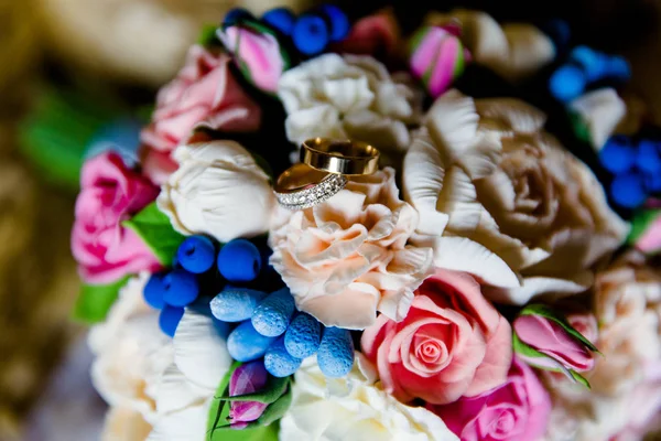 Anillos de oro de boda en un ramo de flores — Foto de Stock