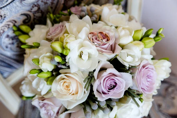 Bagues en or de mariage sur un bouquet de fleurs — Photo