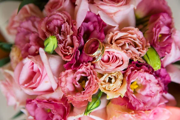 Bagues en or de mariage sur un bouquet de fleurs — Photo