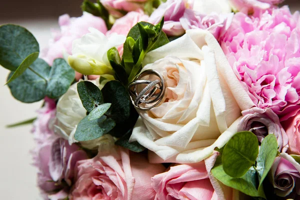 Anillos de oro de boda en un ramo de flores — Foto de Stock