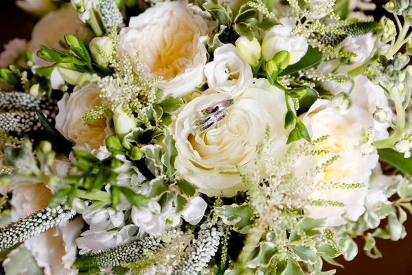 Anillos de oro de boda en un ramo de flores — Foto de Stock