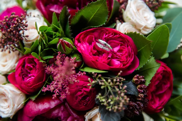 Bagues en or de mariage sur un bouquet de fleurs — Photo