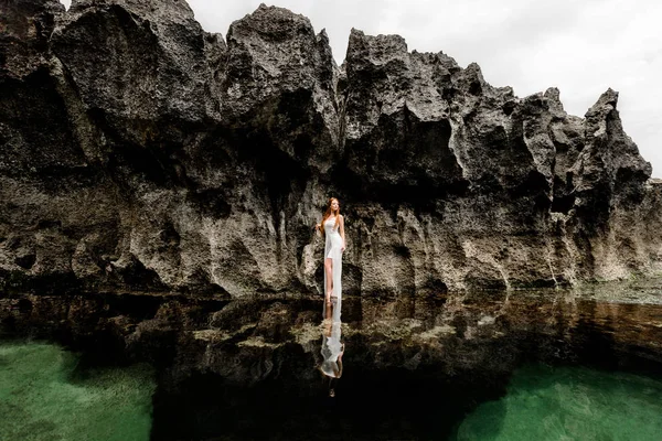 Menina em um riacho do mar perto do penhasco — Fotografia de Stock