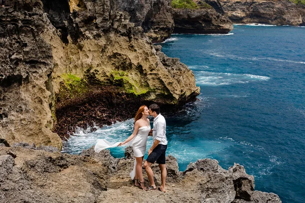 Jovem casal se beijando em um penhasco junto ao mar — Fotografia de Stock