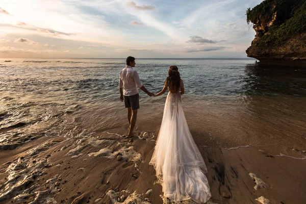 Junges Paar läuft am Strand am Wasser entlang — Stockfoto
