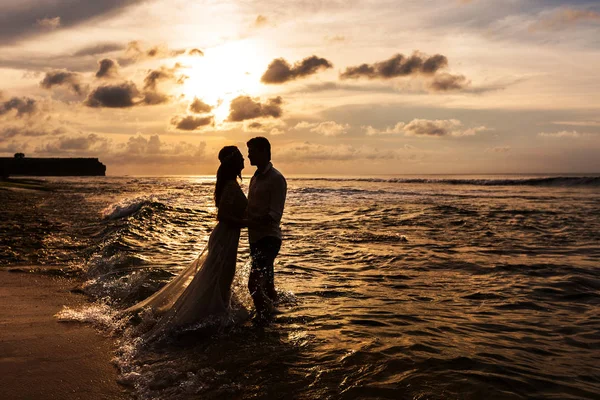 Nowożeńcy na plaży o zachodzie słońca — Zdjęcie stockowe