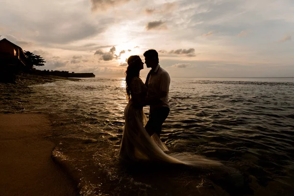 Recién casados en la playa al atardecer — Foto de Stock