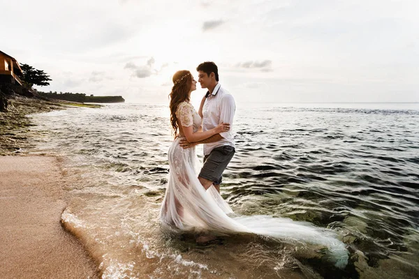 Recién casados en la playa al atardecer —  Fotos de Stock