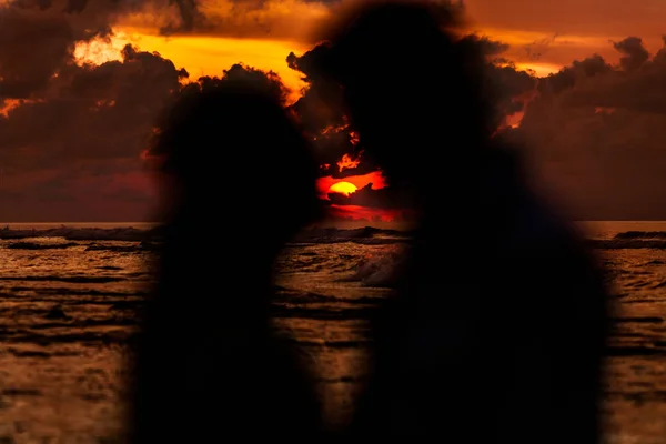 Jovem casal na praia ao pôr do sol — Fotografia de Stock