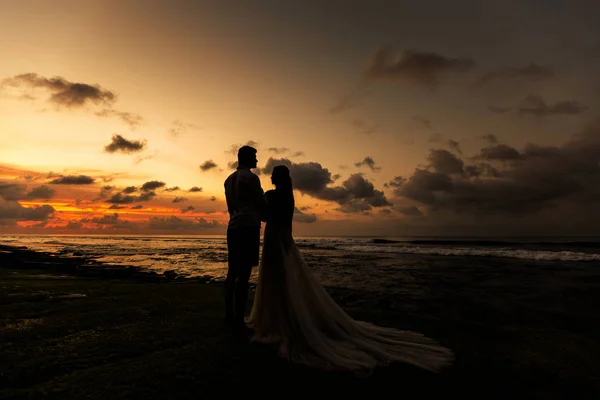 Recién casados en la playa al atardecer —  Fotos de Stock