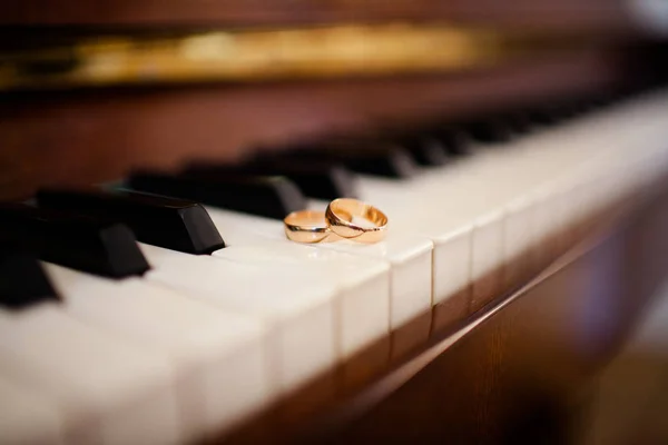 Les alliances reposent sur les touches du piano — Photo