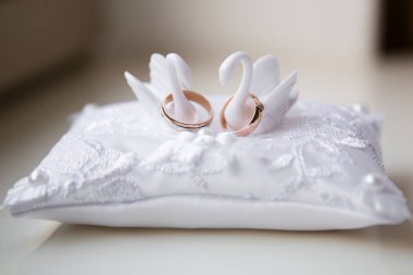 Beyaz bir yastıküzerinde bir çift alyans