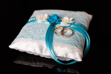 Mavi yastıkta bir çift alyans