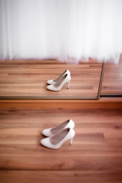 The reflection in the mirror of womens shoes on the floor