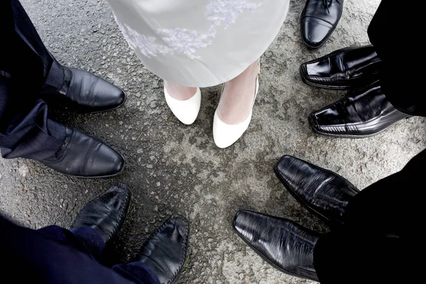 Ноги невесты окружены мужскими ногами в черных туфлях . — стоковое фото