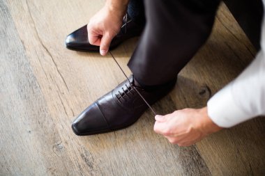 Ayakkabı bağcığı bağlayan adam.