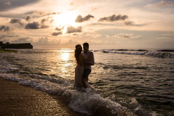 Pareja joven en la playa al atardecer —  Fotos de Stock