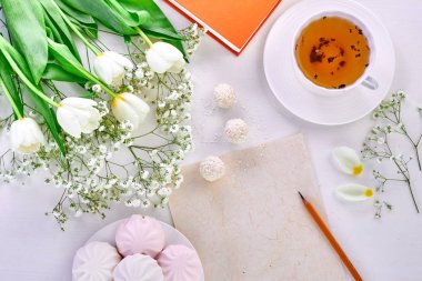 Öğretmenler Günü, Dünya Kadınlar Günü, Anneler Günü. Çay fincanı, lale buketi ve çizim için boş kağıt