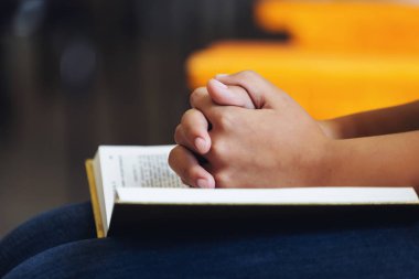 Kutsal Kitap'la dua eden bir kız el