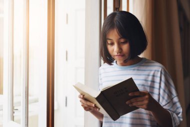 Kız Kutsal Scriptur ile birlikte dua kitabı okuyor