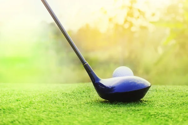 Yeşil çim üzerinde golf kulüpleri ve golf topları