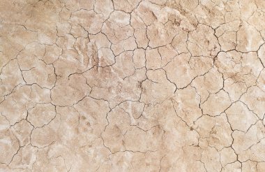 Zemin, kuraklık ve ölüm kavramına sahip arka plan veya grafik tasarımı için üst görünümde çatlaklar var..