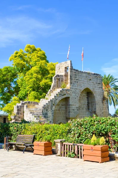 Incrível abadia de Bellapais na pequena cidade cipriota Bellapais capturado em uma imagem vertical com árvores verdes ao redor. A ruína de um mosteiro do século XIII está localizada no norte de Chipre turco — Fotografia de Stock