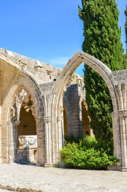 Kıbrıs'ın Kuzey Kıbrıs bölgesindeki küçük Bellapais şehrindeki önemli Bellapais Manastırı'nın antik kalıntıları. Manastır popüler bir turistik yerdir. Yukarıda mavi gökyüzü ile dikey bir resim üzerinde yakalanan