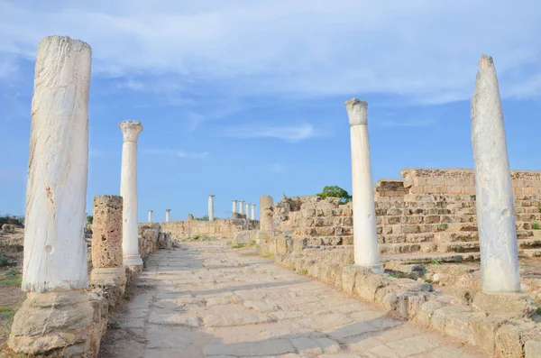 Well preserved ancient Corinthian columns with wall ruins with blue sky above. The ruins were part of famous Salamis Gymnasium. Salamis was an ancient Greek city-state located in Northern Cyprus
