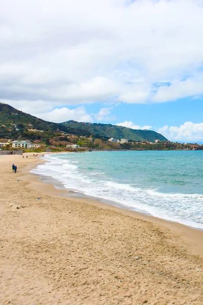 Playa de arena en Sicilia Cefalu tomada con varias personas en un día nublado durante la temporada baja. La pequeña ciudad en la costa tirrena es uno de los principales destinos turísticos de Italia —  Fotos de Stock