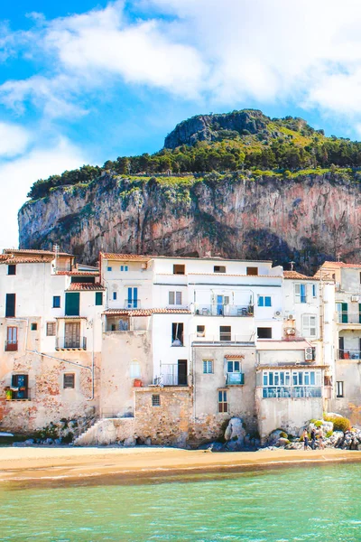 Belles maisons traditionnelles sur la côte de la mer Tyrrhénienne à Cefalu, Sicile, Italie. Derrière les bâtiments magnifique rocher surplombant la baie. L'étonnante ville sicilienne est un lieu touristique populaire — Photo