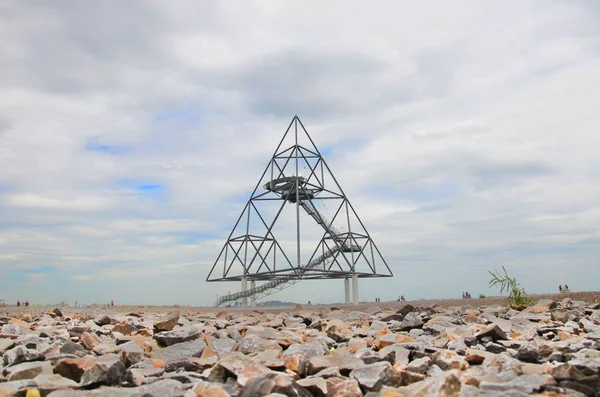 Fotografia no piso térreo do Tetraedro em Bottrop, Alemanha, tirada em um dia nublado de verão. A estrutura de aço walkable na forma de um tetraedro construído em um depósito de mina é popular entre os turistas — Fotografia de Stock
