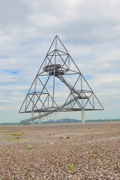 Tetraedro em Bottrop alemão tomado em um dia nublado de verão. A estrutura de aço montável construída sobre um depósito de minas na região da Renânia do Norte-Vestefália faz lembrar a tetrix de Sierpinski — Fotografia de Stock