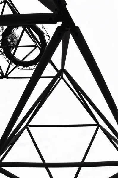 Vista incrível da construção de aço do Tetraedro em Bottrop, Alemanha tomada de baixo contra o céu branco. Uma estrutura de aço passeável em forma de um tetraedro tirado em uma foto em preto e branco — Fotografia de Stock