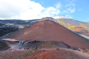 Etna Dağı, Sicilya, İtalya - 9 Nisan 2019: Etna Dağı'ndaki Silvestri kraterlerinde yürüyen yürüyüşçüler. Arka planda kar olan Etna volkanının en tepesi. Popüler turistik nokta