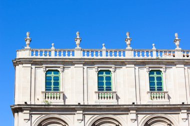 Catania, Sicilya, İtalya tarihi üniversite binasının ön tarafında yakın resmi. Catania Üniversitesi Sicilya'nın en eski üniversitesidir. Beyaz cephe, yeşil pencereler, balkon