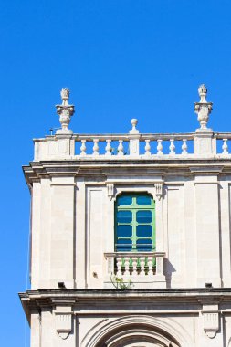 Catania, Sicilya, İtalya'da tarihi üniversite binasının kenarını yakalayan ayrıntılı fotoğraf. Geleneksel parlak cephe, yeşil pencere ve çatı balkon. Sicilya'nın en eski üniversitesi